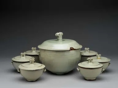 Pale green glazed Deichmann soup tureen surrounded by matching smaller covered bowls, with raised lid handles.