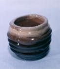 Small rounded Hagen coil pot with horizontal ridges, pale glazed rim and dark blue-green lower body.