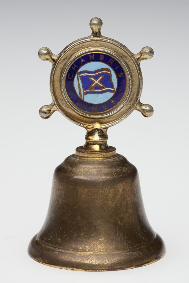 Brass souvenir handbell with a ship’s-wheel handle and blue Chandris Lines badge.