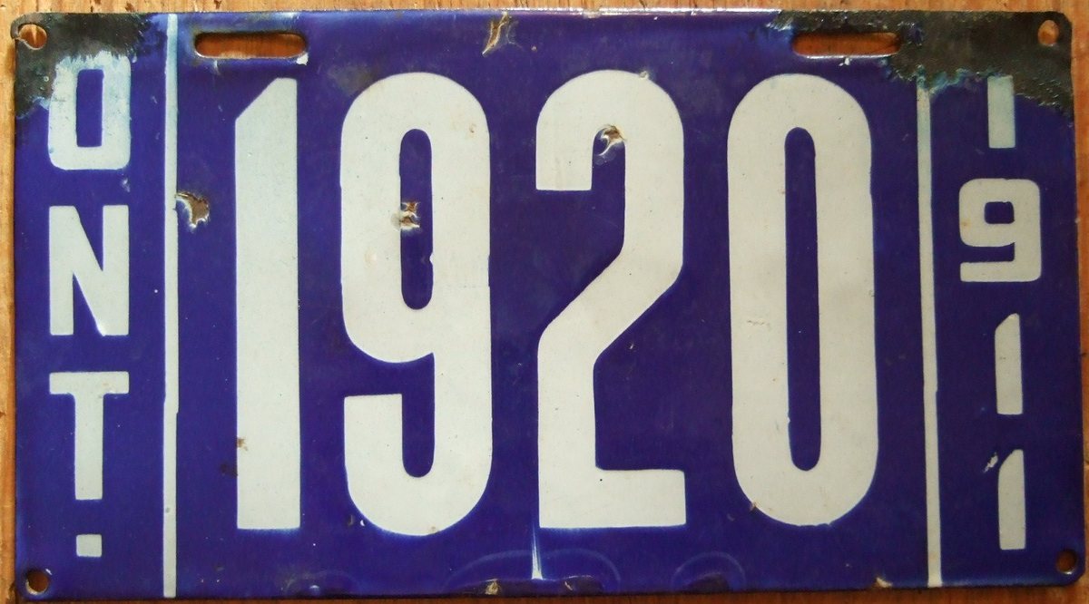 Blue and white Ontario porcelain licence plate numbered 1920, with the year 1911 vertically at right and visible edge chips