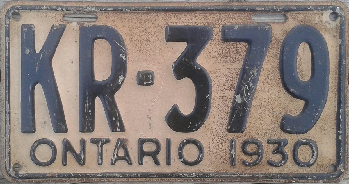 Black-lettered Ontario licence plate KR-379 dated 1930, showing scratches, worn paint and scattered corrosion