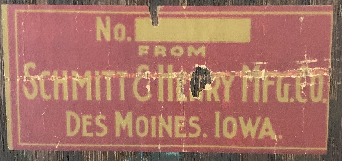 Worn red and yellow Schmitt & Henry Manufacturing Company furniture label naming Des Moines, Iowa