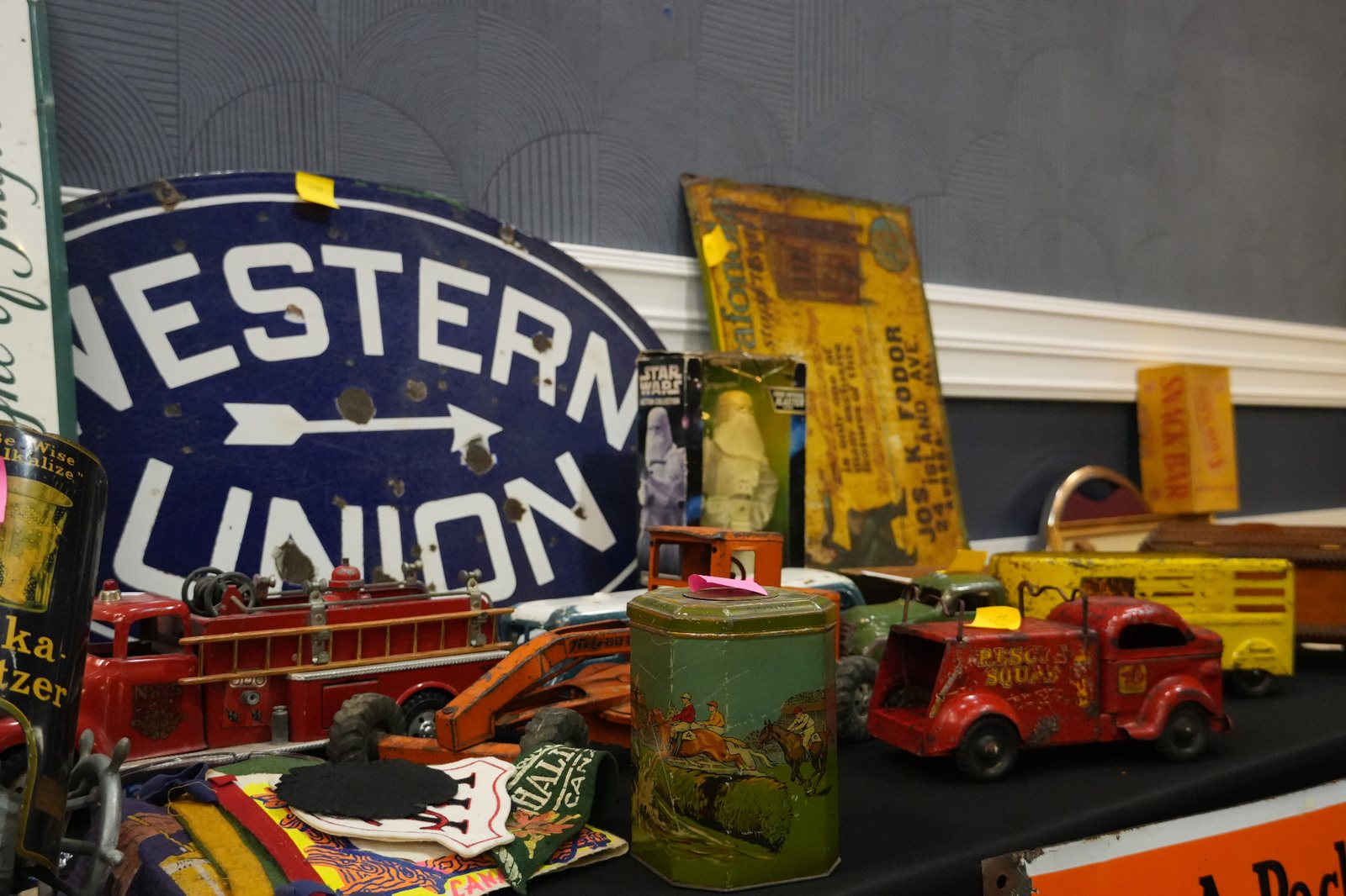 A blue Western Union sign and red toy vehicles from a past show